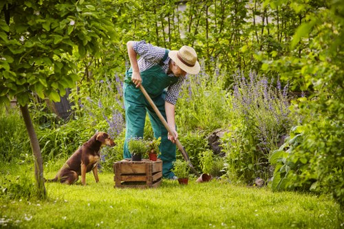 Gardener working on a Beckenham front garden with tools and bags of green waste